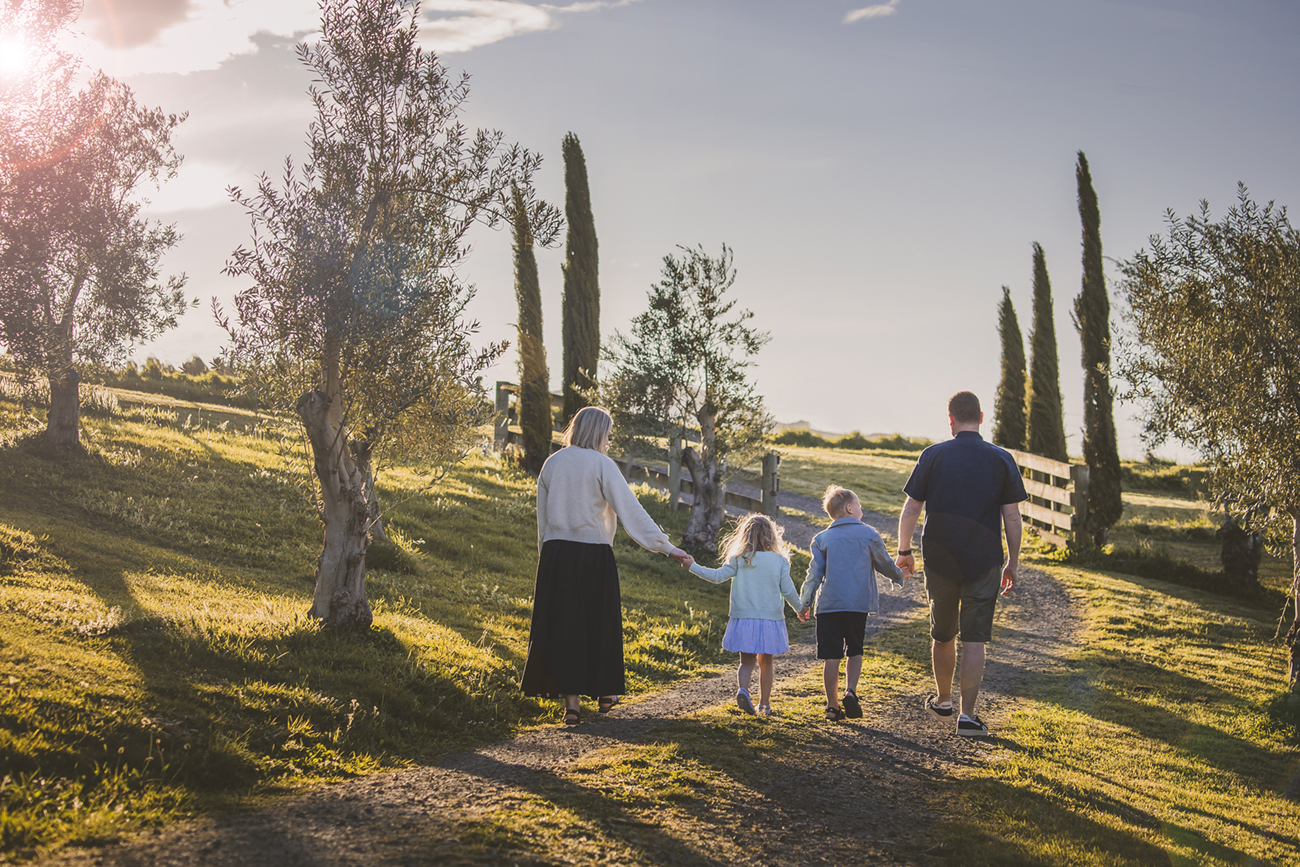 Family Portraits in Italy. Family Portraits in Rome, Naples, and Amalfi Coast. Family Friendly Activities in Italy. Best Italian Photographer. Family walking in olive grove with cypress trees in background